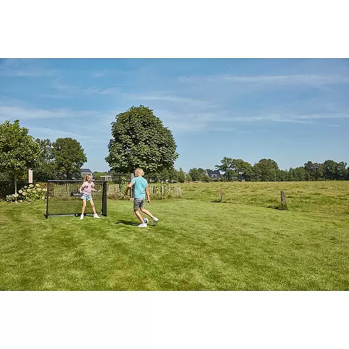 Salta Fußballtor - 180 x 60 x 120 cm, Schwarz - Zwei Kinder spielen Fußball auf einer sonnigen Wiese, ein Kind verteidigt ein schwarzes tragbares Fußballtor.