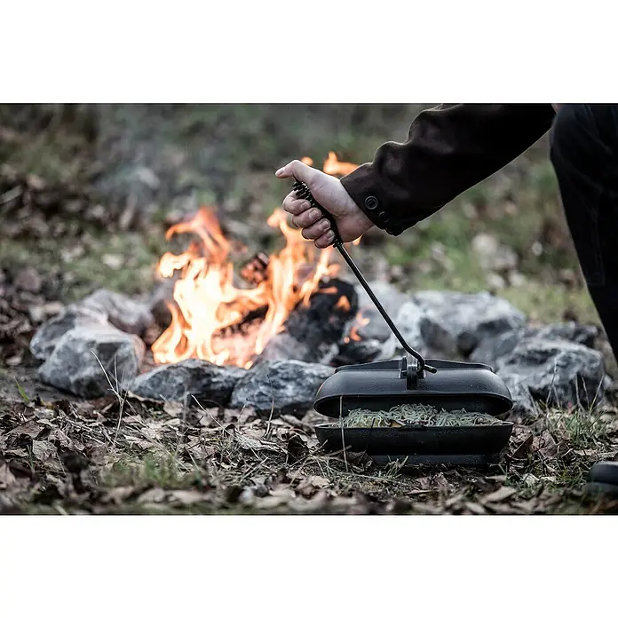 Petromax Deckelheber - Passend für: Dutch Oven Deckel, Länge: 34 cm - Ein gusseiserner Dutch Oven steht über einem Lagerfeuer, bereit zum Kochen. Perfekt für Outdoor-Abenteuer und köstliche Mahlzeiten in der Natur.