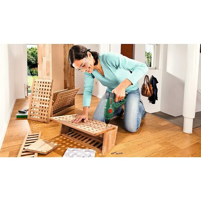 Bosch Power for All 12V Akku-Bohrhammer Uneo - 12 V, 1 Akku, 2 Ah, 0,5 J - Frau montiert ein Holzregal mit einem grünen Akkuschrauber. Heimwerken leicht gemacht mit dem passenden Werkzeug für Holzkonstruktionen.
