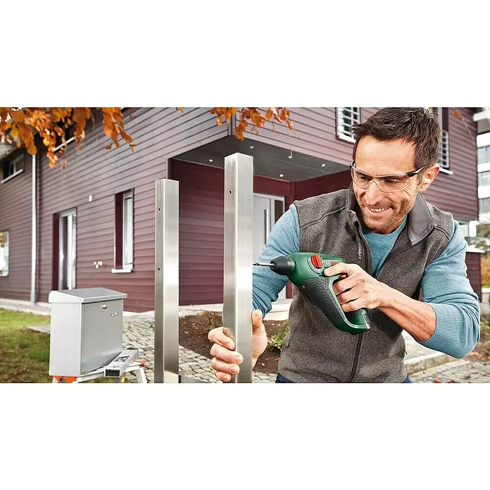 Bosch Power for All 12V Akku-Bohrhammer Uneo - 12 V, 1 Akku, 2 Ah, 0,5 J - Mann bohrt mit einem grünen Bosch-Akkuschrauber ein Loch in ein Edelstahlpfosten. Der Akkuschrauber ist ein kompaktes, leistungsstarkes Werkzeug.