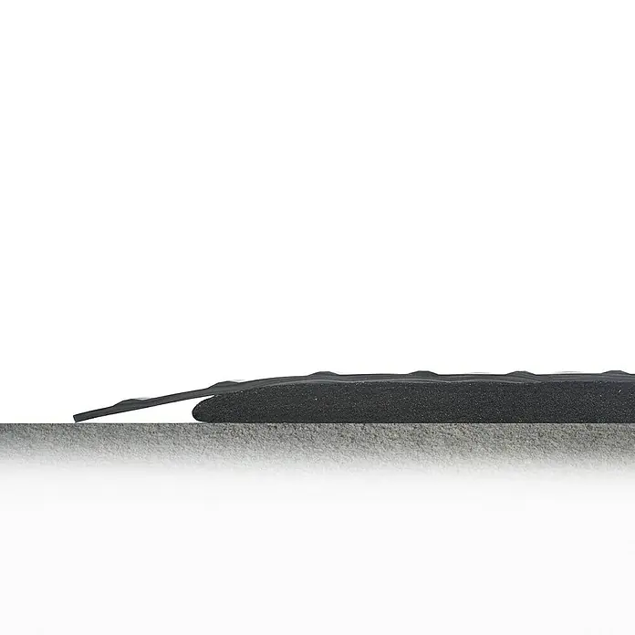 Coba Anti-Ermüdungsmatte Deckplate Meterware - Breite: 60 cm, Rutschfest - Eine Nahaufnahme eines schwarzen Türschwellenrampe mit einem glatten Übergang, ideal zur Überwindung kleiner Höhenunterschiede im Innenbereich.