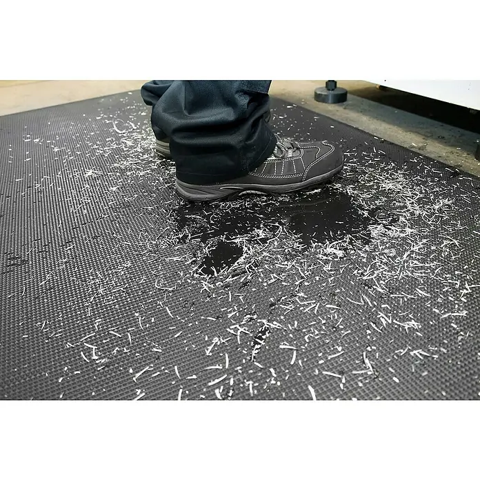 Coba Anti-Ermüdungsmatte Orthomat®-Ultimate - 150 x 90 cm, Schwarz - Ein Tritt auf einer schwarzen Anti-Ermüdungsmatte. Ideal für Arbeitsbereiche, die Komfort und Sicherheit fordern.
