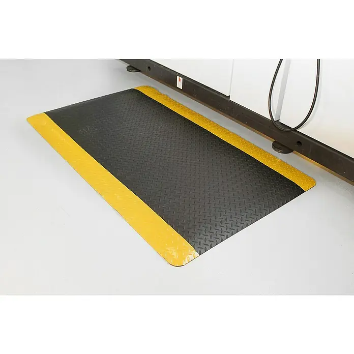 Coba Anti-Ermüdungsmatte Deckplate ProfiSafe Meterware - Breite: 90 cm, Rutschfest - Ein rechteckiger schwarzer Bodenschutzmatte mit gelben Sicherheitsstreifen an den Enden, ideal für Werkstätten oder Industriebereiche.