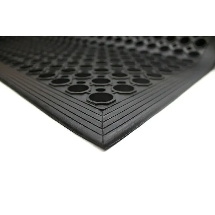 Coba Ringmatte Rampmat - 150 x 90 cm, Schwarz - Nahaufnahme einer schwarzen Anti-Ermüdungsmatte mit Löchern und abgeschrägten Kanten, ideal für den Einsatz in gewerblichen Küchen.