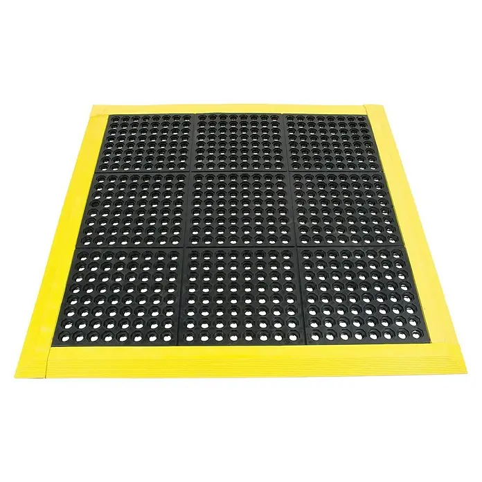 Coba Anti-Ermüdungsmatte Solid Fatigue-StepGelochte Oberfläche - Quadratische, modulare Anti-Ermüdungsmatte mit gelbem Rahmen. Perfekt für industrielle Arbeitsplätze, bietet Komfort und Sicherheit.