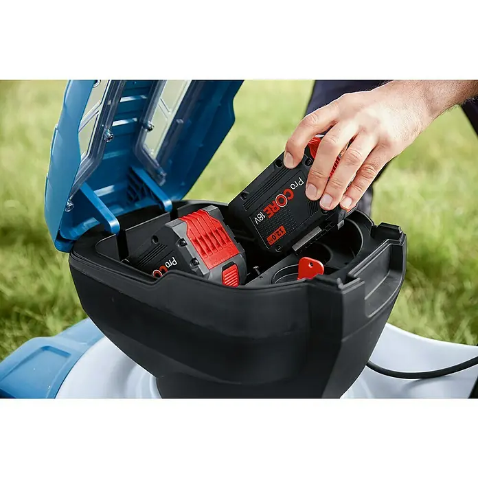 Bosch Professional AMPShare 18V Akku-Rasenmäher GRA 18V2-46 - 18 V, Ohne Akku, Schnittbreite: 46 cm - Ein Mann legt einen 12,0 Ah ProCORE18V Akku in ein Fach eines Rasenmähers.