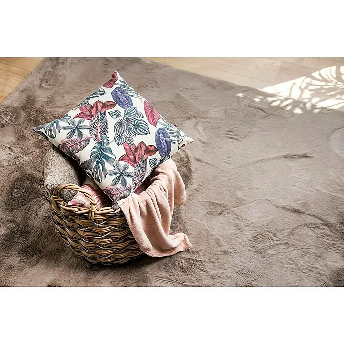 Alfombra de pelo corto Toscana - Beige, 110 x 60 cm, 100% Poliéster - Cojín con estampado botánico en una cesta de mimbre sobre una alfombra mullida, que añade un toque de elegancia natural al espacio.