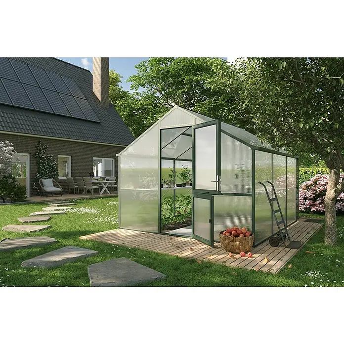 KGT Gewächshaus Nelke III - Außenmaß inkl. Dachüberstand (B x T): 297 x 323 cm, Material Seitenwand: Kunststoff, 16 mm, Tannengrün - Das Bild zeigt ein Gewächshaus mit geöffneter Tür, flankiert von einem Korb Äpfel und einer Sackkarre, vor einem grünen Garten.