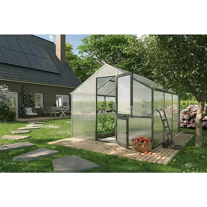 KGT Gewächshaus Nelke III - Außenmaß inkl. Dachüberstand (B x T): 297 x 323 cm, Material Seitenwand: Kunststoff, 16 mm, Anthrazit-grau - Das Bild zeigt ein Gewächshaus mit geöffneter Tür auf einer Holzplattform, umgeben von einem gepflegten Garten und einem Haus.