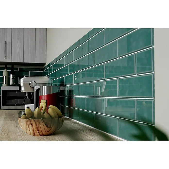 Modern Style Wandfliese Emotion Verde 800 - 9,8 x 29,8 cm, Grün, Glänzend - Detailaufnahme einer Küchenarbeitsplatte mit einer Schale Bananen, einer Kaffeemaschine und grünen Fliesen als Spritzschutz.