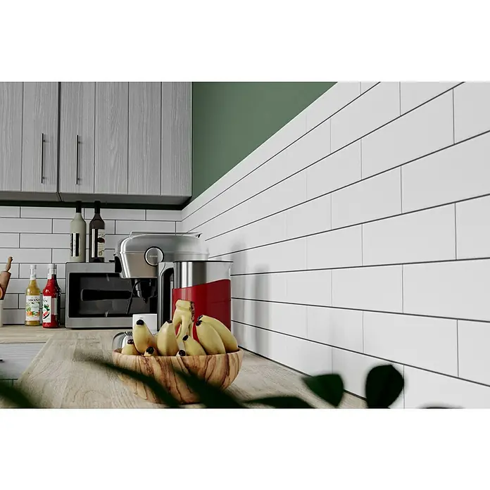 Modern Style Wandfliese Urban Blanco - 7,5 x 30 cm, Weiß, Matt - Nahaufnahme eines Küchentisches mit einer Schüssel Bananen und Küchengeräten mit weißer Metrofliesenwand.