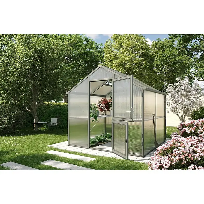 KGT Gewächshaus Iris II - Außenmaß inkl. Dachüberstand (B x T): 233 x 217 cm, Material Seitenwand: Kunststoff, Anthrazit-grau - Nahaufnahme eines Gewächshauses im Garten, das Pflanzen beherbergt und von blühenden Büschen umgeben ist, die ein ruhiges Ambiente schaffen.