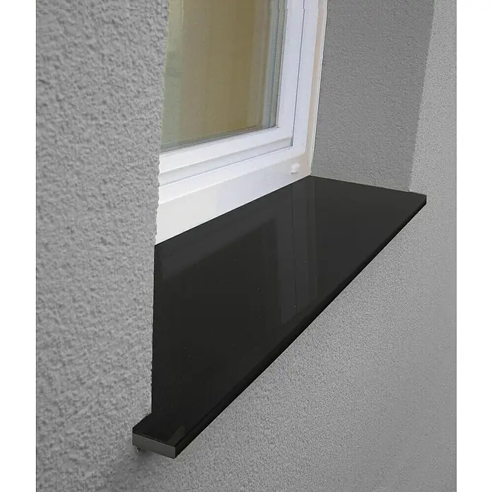 Fensterbank Absolut Black - 88 x 17,5 x 2 cm, Schwarz, Naturstein - Nahaufnahme einer schwarzen Fensterbank unter einem weißen Fenster. Die Textur der grauen Wand sorgt für einen Kontrast.