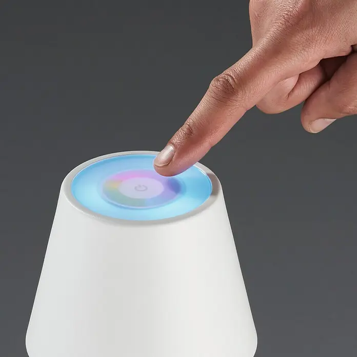 FHL easy Akku-Tischleuchte COSENZA - 2 W, L x B x H: 12 x 12 x 38 cm, Sandweiß, RGB, 1 Stk. - Finger berührt einen farbwechselnden LED-Nachttischlampe, die ein sanftes Umgebungslicht erzeugt und einfach zu bedienen ist.