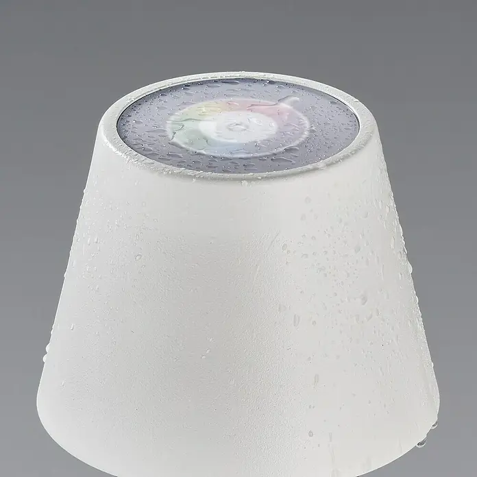 FHL easy Akku-Tischleuchte COSENZA - 2 W, L x B x H: 12 x 12 x 38 cm, Sandweiß, RGB, 1 Stk. - Nahaufnahme eines weißen, kegelförmigen Produkts mit Wassertropfen, das oben ein kreisförmiges Display mit Farbübergang hat.