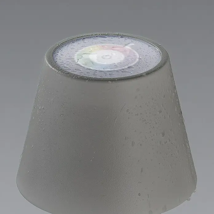 FHL easy Akku-Tischleuchte COSENZA - 2 W, L x B x H: 12 x 12 x 38 cm, Sand, RGB, 1 Stk. - Nahaufnahme einer grauen, kegelförmigen Lampe mit Wassertropfen und einem Lichtkranz auf der Oberseite.