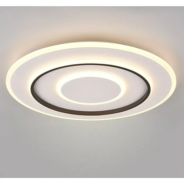 Reality Leuchten Plafón LED redondo Jora - 55 W, Ø x Al: 60 x 6 cm, Blanco, Blanco cálido - Primer plano de una moderna lámpara de techo LED redonda con un diseño en blanco y negro, que emite una luz cálida y brillante.