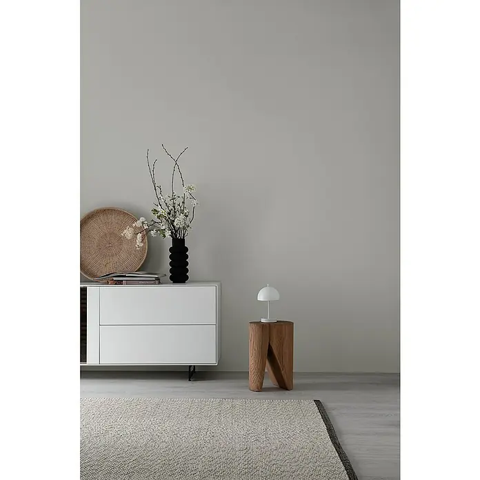 SCHÖNER WOHNEN-Kollektion Akku-Tischleuchte KIA - 2 W, L x B x H: 16 x 16 x 27 cm, Weiß, Mehrfarbig - Einrichtungsszene mit weißem Sideboard, schwarzer Vase mit Blumen, Holzhocker mit Lampe und einem stilvollen Teppich im Vordergrund.