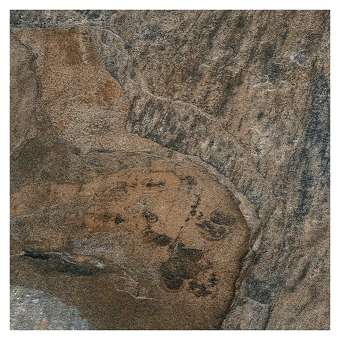 Decocer by Cinca Feinsteinzeugfliese Splash Indian - 15 x 15 cm, Blaubraun, Matt - Detailaufnahme einer keramischen Fliese in Steinoptik, die natürliche Brauntöne und eine robuste Textur aufweist.