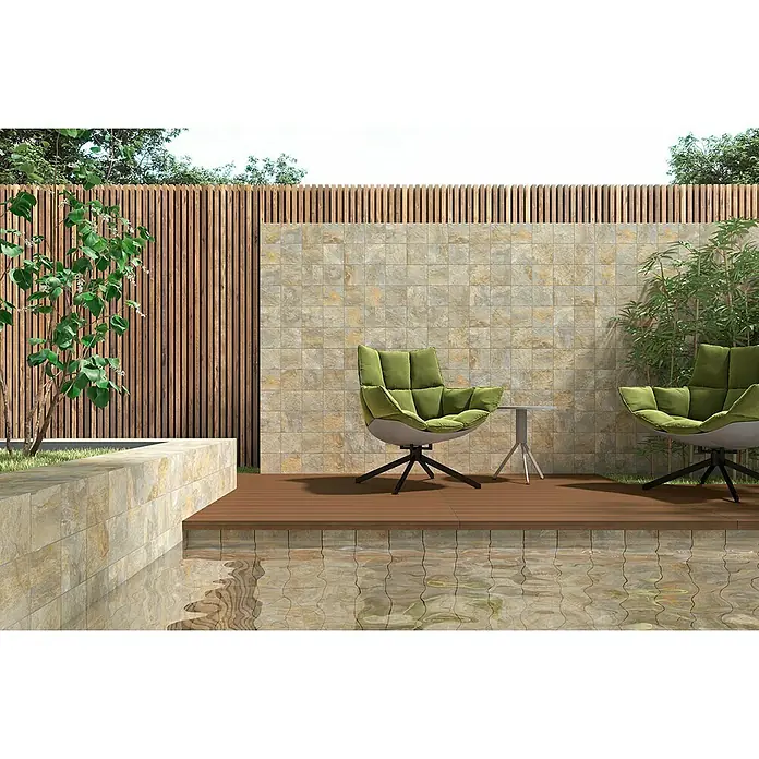 Decocer by Cinca Feinsteinzeugfliese Splash Grege - 15 x 15 cm, Braun, Matt - Einladender Außenbereich mit stilvollen, grünen Sesseln auf einer Holzterrasse, die an einen Pool mit reflektierenden Fliesen grenzt.