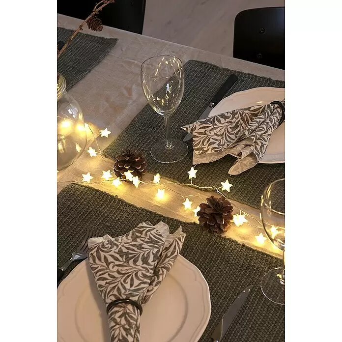 Konstsmide LED-Lichterkette - Innen, Lichtfarbe: Warmweiß, Anzahl Leuchtmittel: 90 Stk., Netzbetrieben - Sternförmige LED-Lichterkette dekoriert einen festlichen Tisch mit Tannenzapfen und Platzsets.