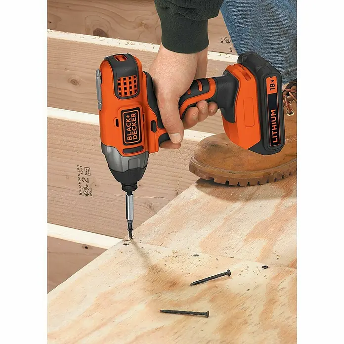 Black+Decker Atornillador de impacto de batería BDCIM18D1A - 18 V, 1 batería, 2 Ah, 155 Nm - Un atornillador de impacto inalámbrico Black+Decker atornillando un tornillo en una tabla de madera, ideal para proyectos de bricolaje.