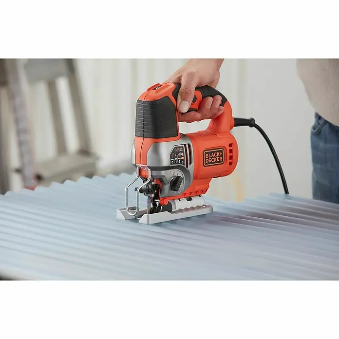 Black+Decker Sierra de calar eléctrica BES610KA5 - 1.000 /min - 3.100 /min, 90 mm - Una sierra de calar Black+Decker, naranja y negra, utilizada sobre una superficie azul. Perfecto para proyectos de bricolaje y mejora del hogar.