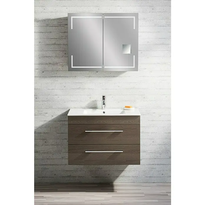 Lanzet K5 Waschtischunterschrank - 87,9 x 50,3 x 57,5 cm, Eiche Maron - Modernes Badezimmer-Waschbecken mit zwei Schubladen und Spiegelschrank mit integrierter Beleuchtung vor einer Betonwand.