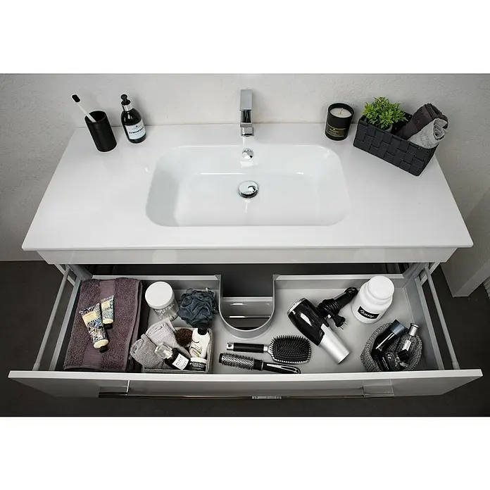 Lanzet K5 Badmöbel-Set K51W2 - 117,9 cm, Weiß - Blick auf ein modernes Waschbecken mit offenem Schubladen-Organizer, der verschiedene Badutensilien wie Handtücher und Haarbürsten enthält.