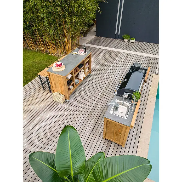Sunfun Zoe Outdoorküchen-Modul Grillbar - Braun, B x T x H: 188 x 67 x 110,2 cm, Teakholz - Hochwinkelaufnahme einer Außenküche mit einer Kochinsel, einem Waschbecken und einer Arbeitsplatte aus Holz auf einer Terrasse.