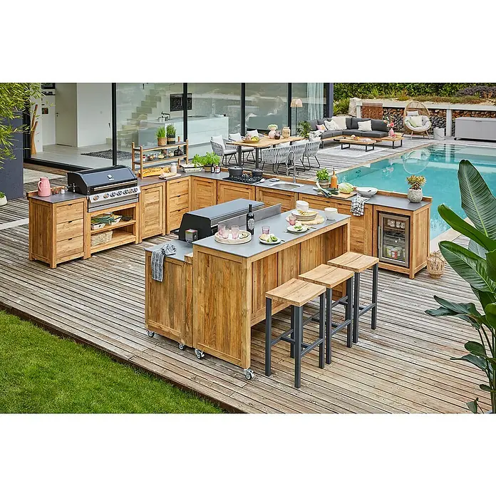 Sunfun Zoe Outdoorküchen-Modul Grillbar - Braun, B x T x H: 188 x 67 x 110,2 cm, Teakholz - Eine Außenküche aus Holz mit Grill, Kochfeld, Spüle, Kühlschrank und Bartheke mit Hockern auf einer Holzterrasse mit Pool im Hintergrund.