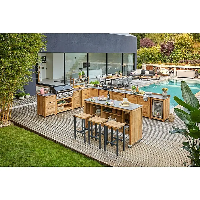 Sunfun Zoe Outdoorküchen-Modul Grillbar - Braun, B x T x H: 188 x 67 x 110,2 cm, Teakholz - Outdoor-Küche mit Grill, Spüle, Kühlschrank und Barhockern auf einer Holzterrasse neben einem Pool.