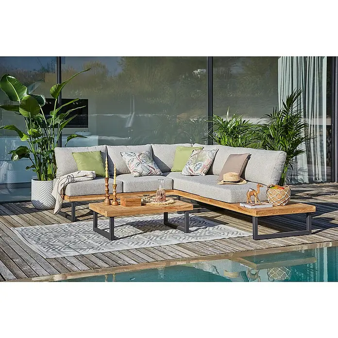 Sunfun Zoe Loungemöbel-Set - 3 -tlg., Teak/Stahl, Hellgrau - Eine graue modulare Gartengarnitur mit Holztisch auf einem gemusterten Teppich neben einem Pool. Ideal für entspannte Stunden im Freien.