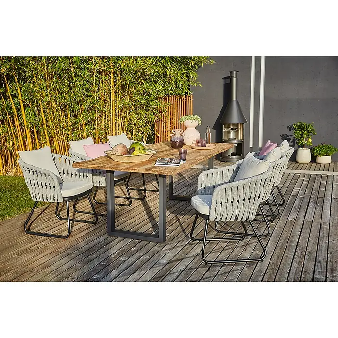 Sunfun Maja Gartenmöbel-Set - 8 -tlg., Teak/Edelstahl/Seilgeflecht, Teak/Grau/Beige, Baumkante/U-Gestell - Gartentischgruppe mit Holztisch und grauen Seilstühlen auf einer Holzterrasse, umgeben von Pflanzen. Dekorative Elemente auf dem Tisch.