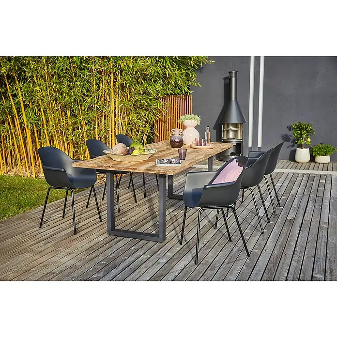 Sunfun Gartenmöbel-Set My - 8 -tlg., Baumkante/U-Gestell, Teak/Edelstahl/Kunststoff, Teak/Grau/Schwarz - Einladender Gartentisch mit sechs Stühlen auf einer Holzterrasse, umgeben von üppigem Grün. Perfekt für entspannte Stunden im Freien.