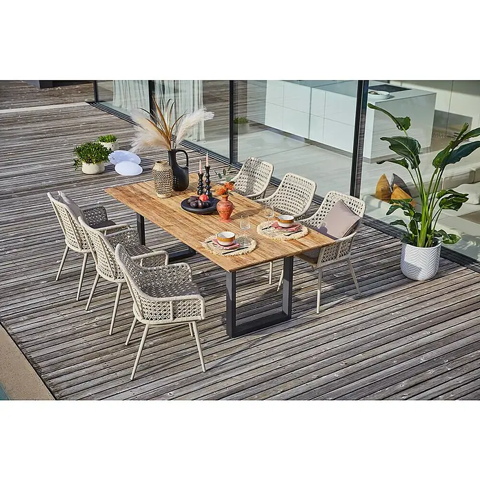 Sunfun Gartenmöbel-Set Zoe Dining - 8 -tlg., Schweizer-Kante/U-Gestell, Teak/Edelstahl/Kunststoffgeflecht, Teak/Grau - Einladender Essbereich im Freien mit einem robusten Holztisch und sechs stilvollen Korbstühlen auf einer Terrasse.