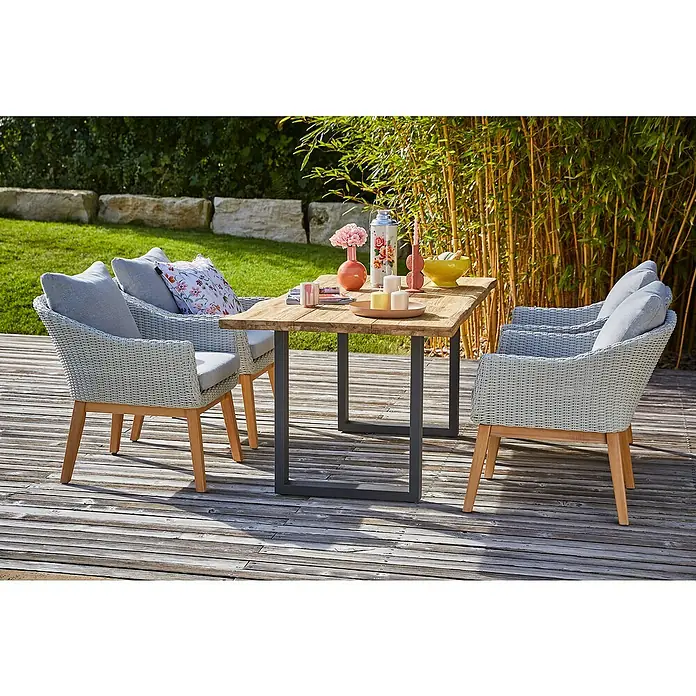 Sunfun Paula Gartenmöbel-Set XL - 6 -tlg., Baumkante/U-Gestell, Teak/Edelstahl/Polyrattan/Aluminium, Teak/Grau/Naturbraun - Ein einladender Esstisch mit vier Korbstühlen im Freien, geschmückt mit Blumen und Kerzen, perfekt für Mahlzeiten im Garten.