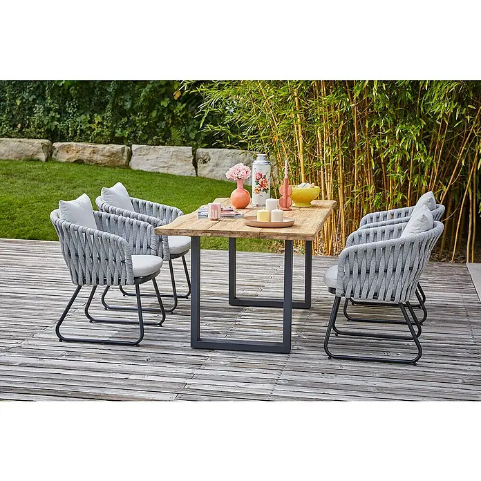 Sunfun Maja Gartensessel - Seilgeflecht, Grau-Beige, B x T x H: 64 x 65 x 77 cm - Gartentisch mit vier grauen Stühlen auf einer Holzterrasse. Dekorative Elemente zieren den Tisch und schaffen eine einladende Atmosphäre.