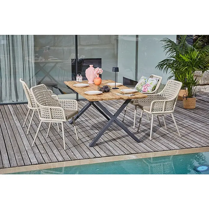 Sunfun Gartenmöbel-Set Zoe Dining - 6 -tlg., Schweizer-Kante/X-Gestell, Teak/Edelstahl/Aluminium/Kunststoffgeflecht, Teak/Grau/Sand - Ein einladender Esstisch mit Korbstühlen und Dekoration auf einer Holzterrasse am Pool.