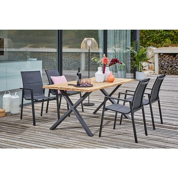 Sunfun Gartentisch - L x B x H: 180 x 90 x 75 cm, Teakholz/Edelstahl, Natur/Anthrazit, Baumkante/X-Fuß - Eine moderne Gartengarnitur mit Holztisch und grauen Stühlen auf einer hölzernen Terrasse.