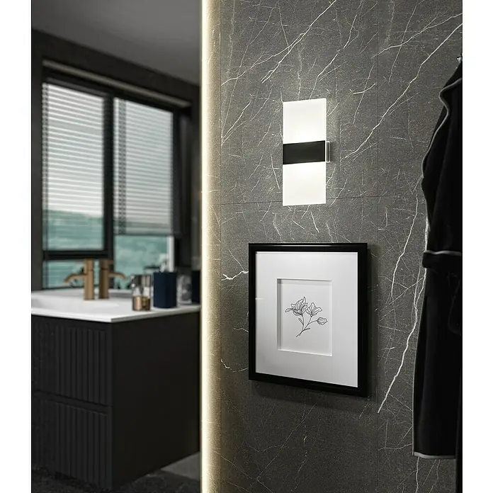 FHL easy Magnetic Akku-Wandleuchte - 3,8 x 9,6 x 22,5 cm, Schwarz, Warmweiß, 2 W, IP20 - Detailaufnahme eines Badezimmers mit einer stilvollen Wandleuchte, einem gerahmten Bild und einem modernen Waschtisch.