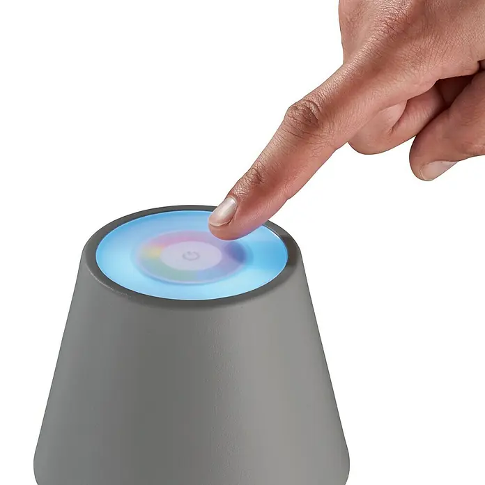 FHL easy Akku-Tischleuchte COSENZA - 2 W, L x B x H: 12 x 12 x 38 cm, Sand, RGB, 2 Stk. - Ein Finger berührt die Oberfläche eines grauen Smart Home Geräts mit farbig beleuchteter Touch-Oberfläche zur Steuerung.