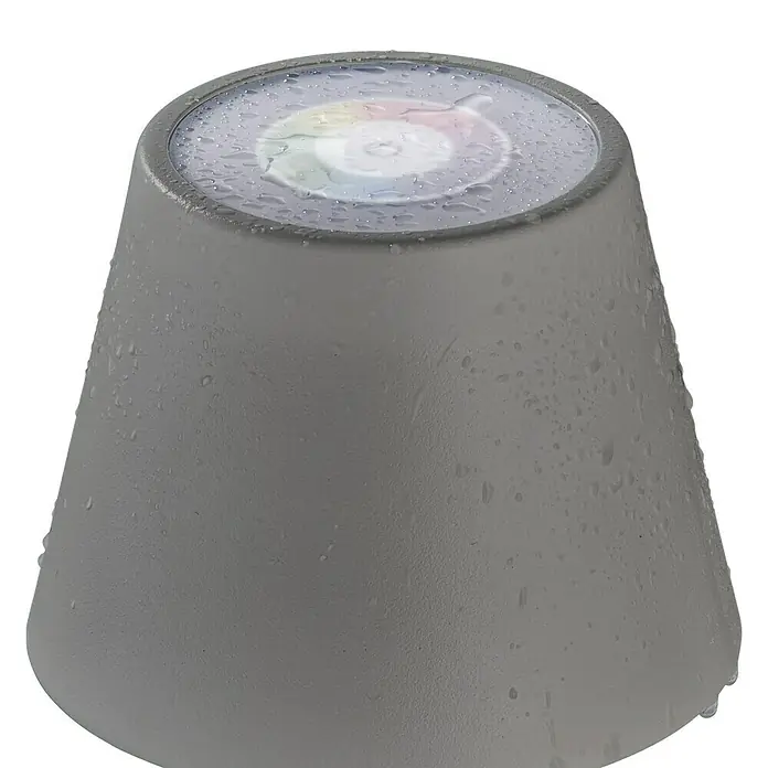 FHL easy Akku-Tischleuchte COSENZA - 2 W, L x B x H: 12 x 12 x 38 cm, Sand, RGB, 2 Stk. - Ein grauer, konisch geformter LED-Gartenstrahler mit Wassertropfen auf der Oberfläche, der im Dunkeln leuchtet.