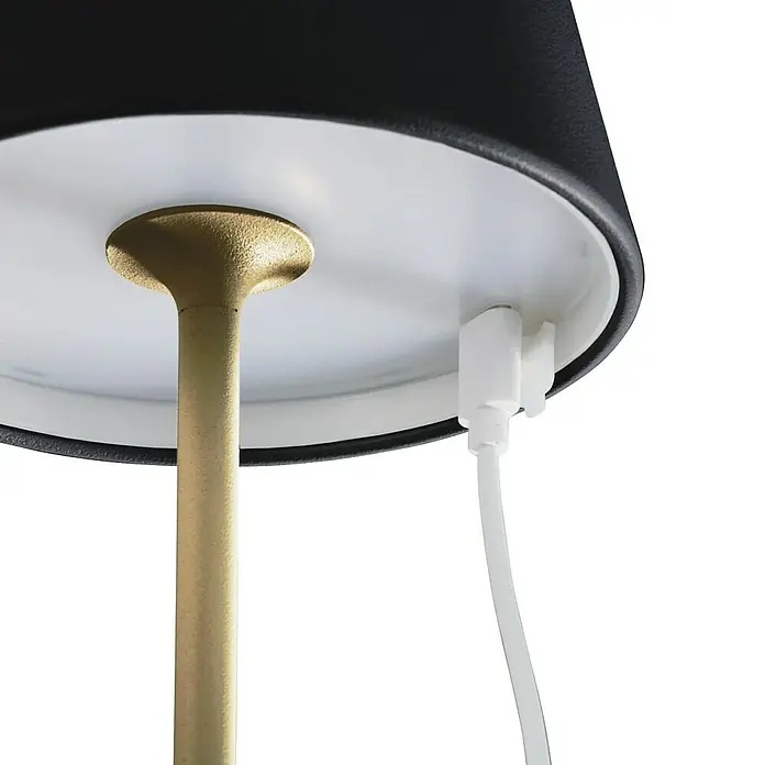 FHL easy Akku-Tischleuchte COSENZA 2.0 - 2 W, L x B x H: 11 x 11 x 34 cm, Sandschwarz/Gold, RGB - Nahaufnahme einer Lampe mit goldenem Stiel und schwarzem Lampenschirm, dazu ein weißes Kabel.