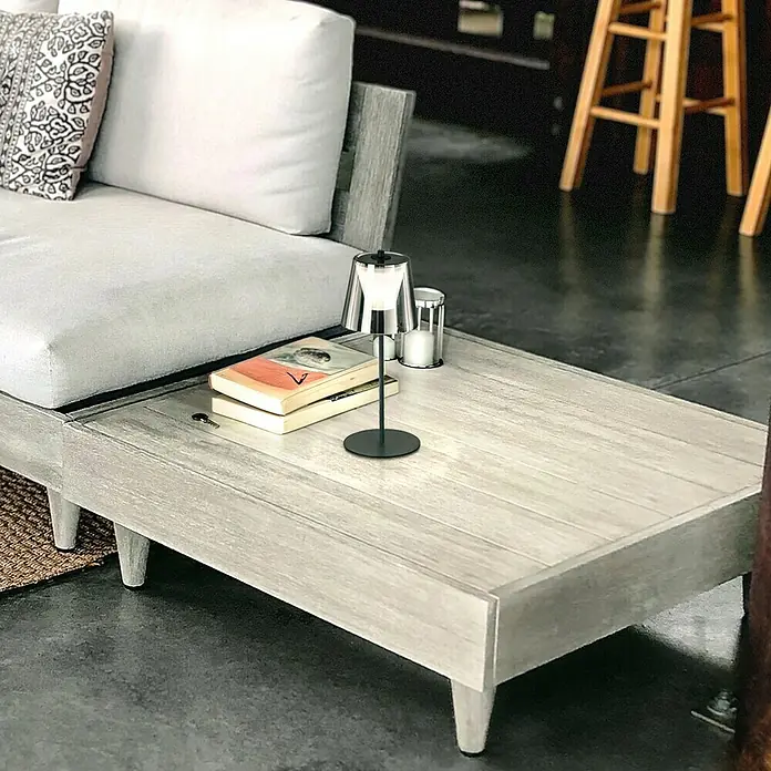 FHL easy Akku-Tischleuchte MARBELLA - 2 W, L x B x H: 14 x 14 x 35 cm, Rauchschwarz/ Sandschwarz, Warmweiß - Elegante Tischleuchte auf einem Couchtisch, neben Büchern und einer Kerze. Das moderne Design passt perfekt zum stilvollen Ambiente.