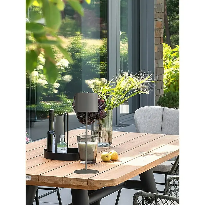 SCHÖNER WOHNEN-Kollektion Akku-Tischleuchte SUN - 2 W, L x B x H: 12 x 12 x 38 cm, Sand, RGB - Ein stilvoller Esstisch im Freien mit einer Tischleuchte, Dekoration und Geschirr, perfekt für Mahlzeiten im Freien.