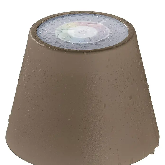 FHL easy Akku-Tischleuchte COSENZA - 2 W, L x B x H: 12 x 12 x 38 cm, Graubraun, RGB, 1 Stk. - Nahaufnahme einer braunen Gartenlampe mit Wassertropfen und buntem Licht, die eine warme und einladende Atmosphäre schafft.