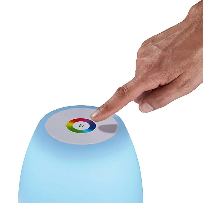 FHL easy Akku-Tischleuchte BARLETTA - 2 W, L x B x H: 16 x 16 x 26 cm, Weiß, RGB - Nahaufnahme einer Hand, die eine farbwechselnde Tischleuchte mit einem farbigen Ring und einem Power-Symbol berührt.
