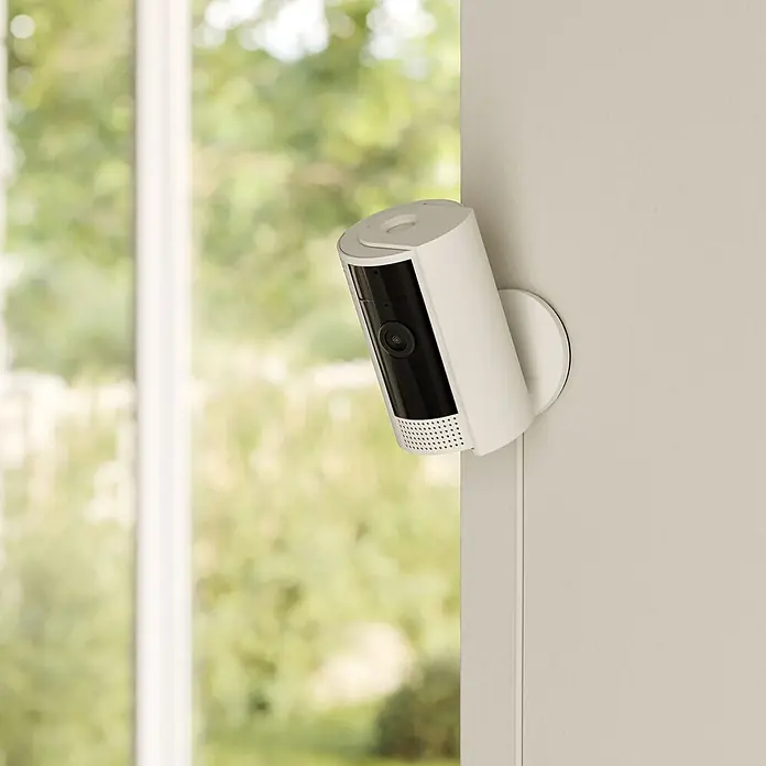 Ring Innenkamera Indoor Cam 2. Gen. - 1.080 Pixel (Full HD), Weiß, 1 Stk. - Nahaufnahme einer Ring Stick Up Cam, einer drahtlosen Sicherheitskamera für den Innen- und Außenbereich, montiert an einer Wand.