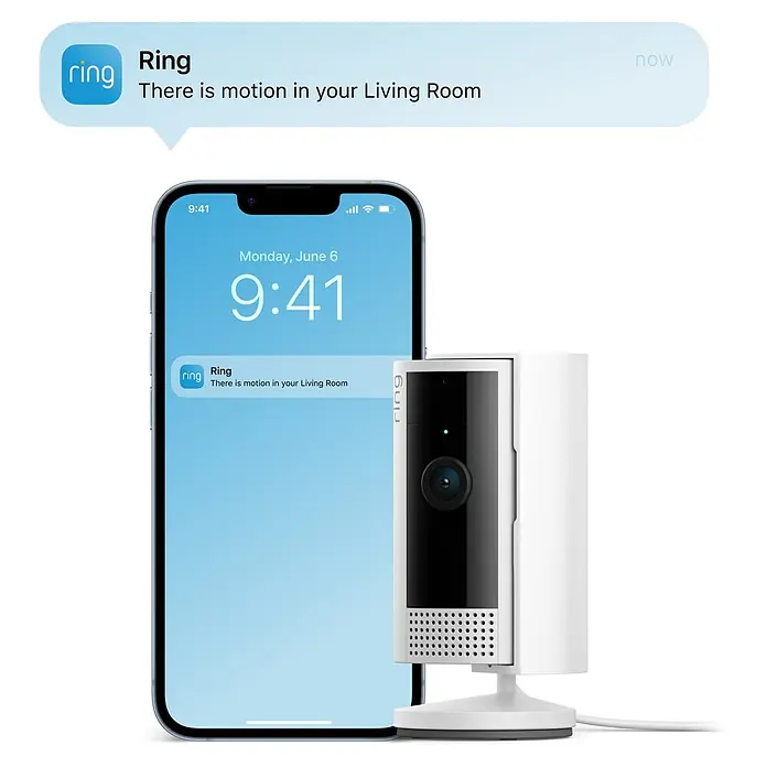 Ring Innenkamera Indoor Cam 2. Gen. - 1.080 Pixel (Full HD), Weiß, 2 Stk. - Nahaufnahme einer Ring Sicherheitskamera neben einem Smartphone, das eine Bewegungsbenachrichtigung anzeigt.